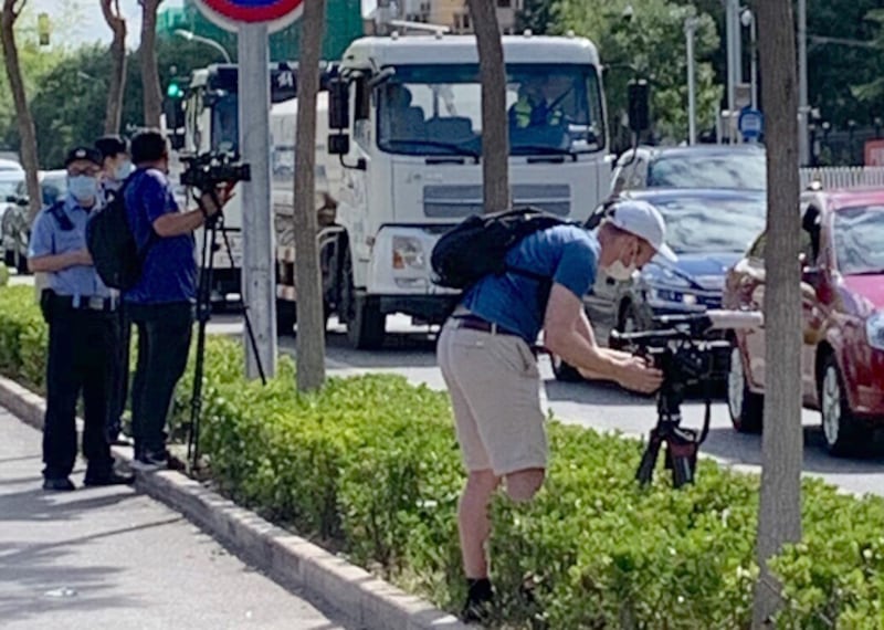 被拒採訪的外媒記者在法院對開馬路邊拍攝，亦遭警察盤查。（小健 攝）