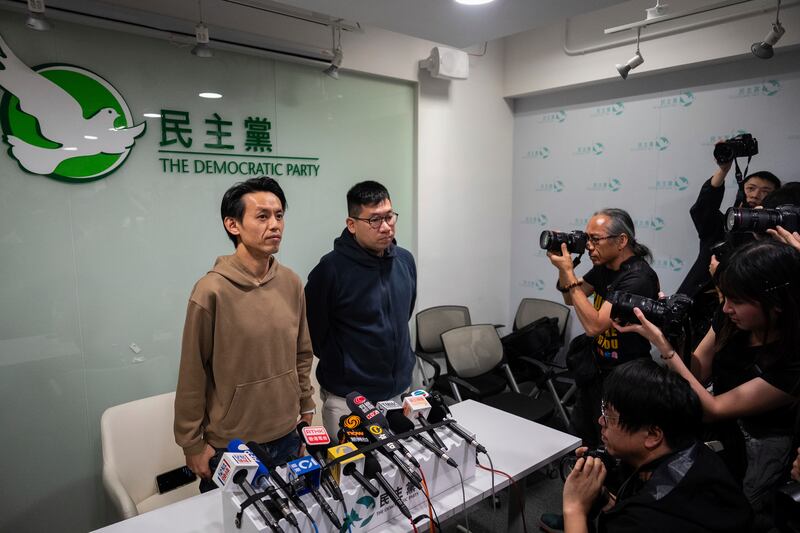 Lo Kin-hei, left, chairman of Hong Kong's Democratic Party and Mok Kin-shing, vice chairman, pose for photographs at a press conference at the office of Hong Kong's Democratic Party in Hong Kong on Sunday, April 13, 2025. (AP Photo/Chan Long Hei)