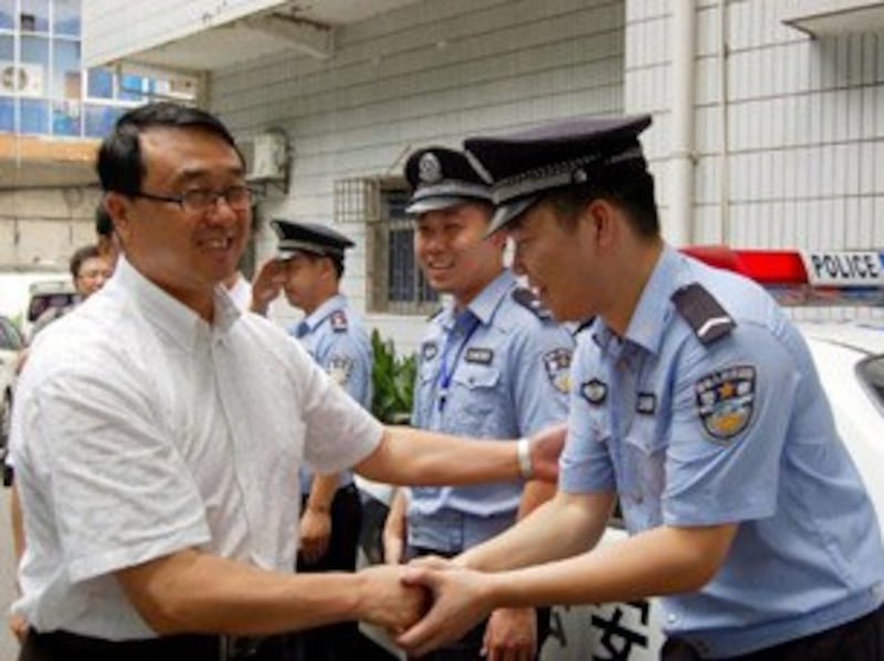 图片： 原重庆市公安局局长王立军与警员握手。 （法新社资料图片）