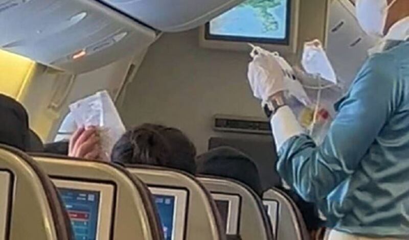 一架大韩航空公司的客机于2月3日降落在大连机场时,机上韩籍旅客被要求挂上白色牌子。(视频截图)