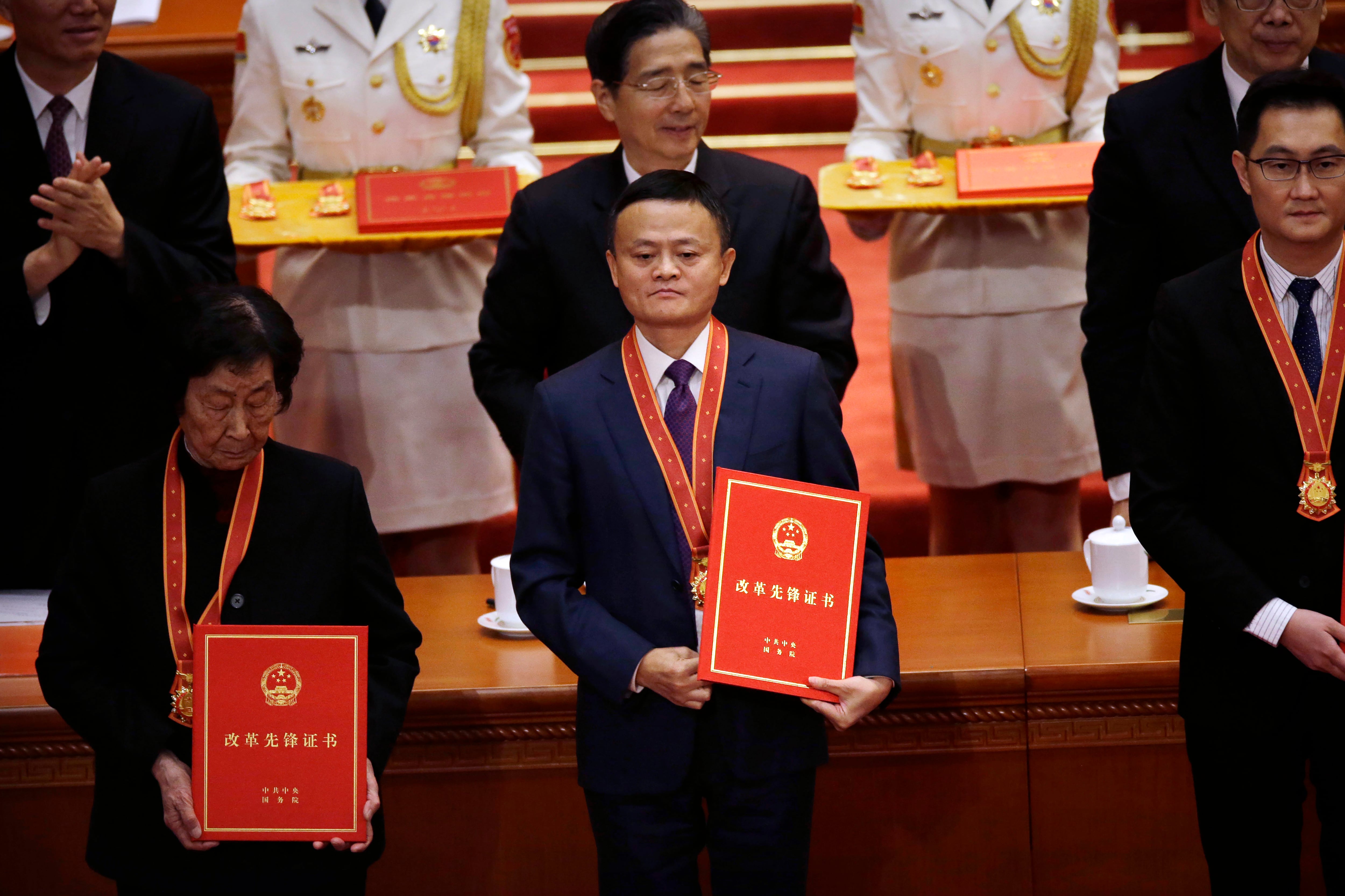 图为2018年12月18日,时任阿里巴巴集团董事长的马云(中)出席在北京人民大会堂举行的纪念中国改革开放40周年大会。