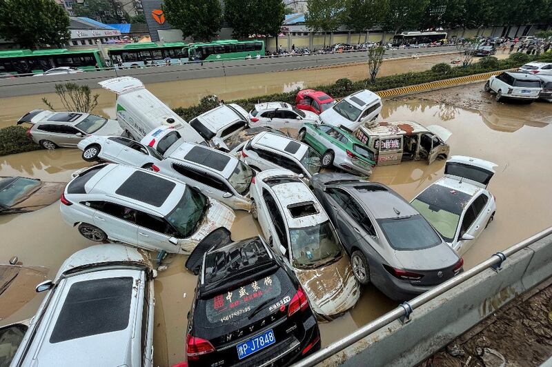 Cars sit in floodwaters after heavy rains hit the city of Zhengzhou in China's central Henan province on July 21, 2021. (Photo by STR / AFP)