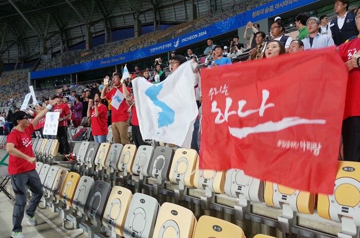 인천아시안게임 개막 하루를 앞둔 지난 18일 경기도 화성종합경기타운에서 열린 북한과 파키스탄의 축구 경기에서 아리랑 통일응원단이 한반도기를 흔들며 북한 선수들을 응원하고 있다.