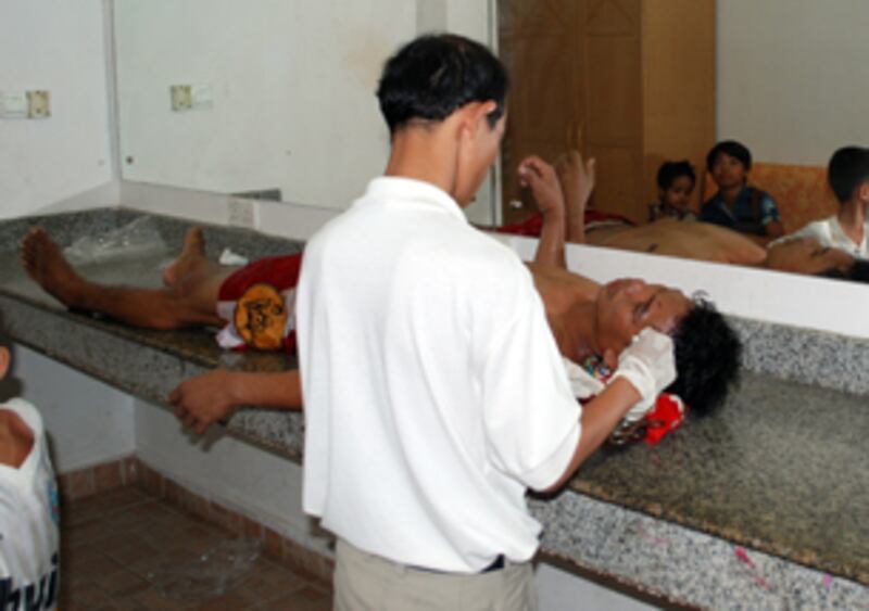 គ្រូពេទ្យកំពុងដេរស្នាមរបួលកីឡាករប្រដាល់ នៅក្នុងបន្ទប់ទឹកសង្វៀនប្រដាល់ទូរទស្សន៍ស៊ីធីអិន (CTN) កាលពីថ្ងៃទី៣១ ខែមីនា ឆ្នាំ២០១៣។