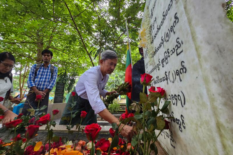 အာဇာနည်ခေါင်းဆောင် ဝန်ကြီးဦးရာဇတ်နဲ့ ရဲဘော်ကိုထွေးတို့ အုတ်ဂူမှာ ၂၀၂၃ ခုနှစ် ဇူလိုင် ၁၉ ရက်နေ့က လာရောက် ဂါရ၀ပြုသူတစ်ဦးကို တွေ့ရစဉ်။ (Photo : RFA)