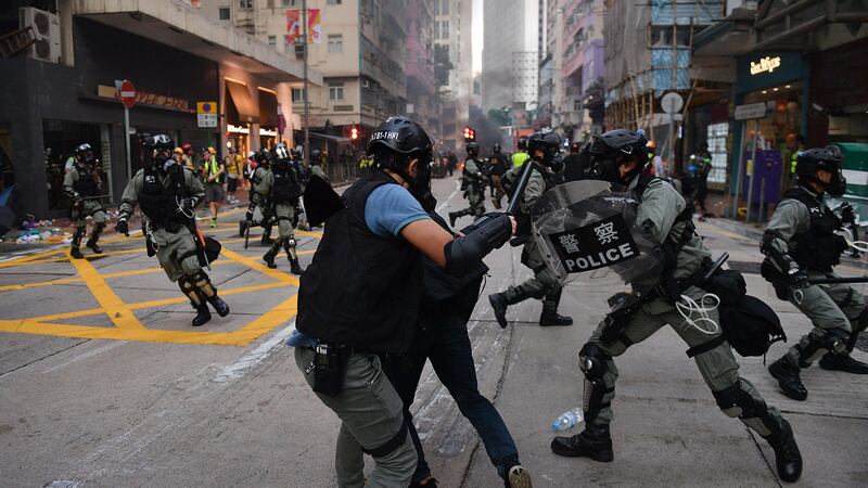 2019年10月1日,香港湾仔区举行示威游行时,警察在街上追捕一名示威者(中)。(法新社)