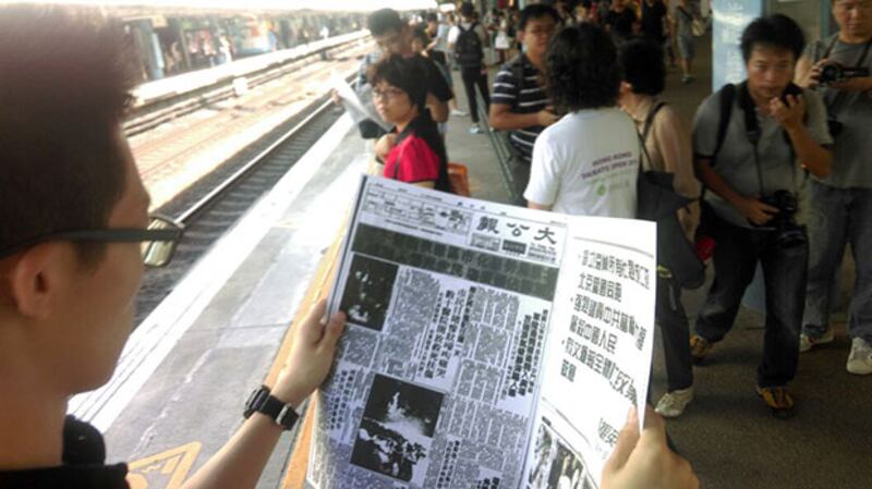 2015年6月3日，學聯成員於月台上閱讀1989年的報紙。(學聯提供)