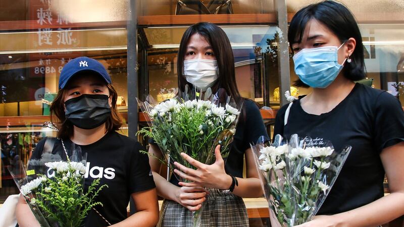 不少市民身穿黑衣、手持白花到事发现场悼念。(张展豪 摄)