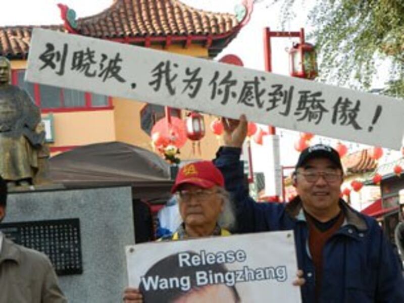 图片:参加游行群众指莫言应该再为刘晓波讲话。 (记者萧融拍摄)