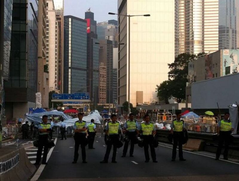 2014年10月15日清早，大量警察由中環和記大廈及大會堂旁的停車場進入干諾道佔領區，清走佔領者帳篷及物資站。（社民連提供）