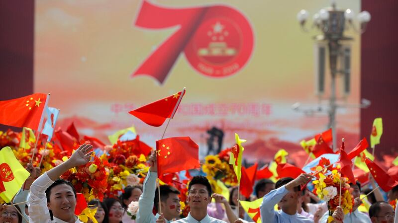 中国国庆70周年上的学生们在挥舞国旗。(美联社)