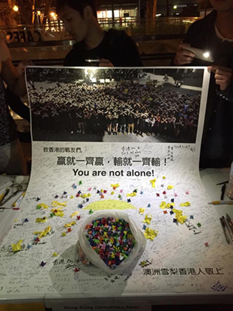 澳大利亞港人在當地中國大使館外﹐簽名支持港人支持民主﹐表示港人“並不孤單”。 (參與者提供)