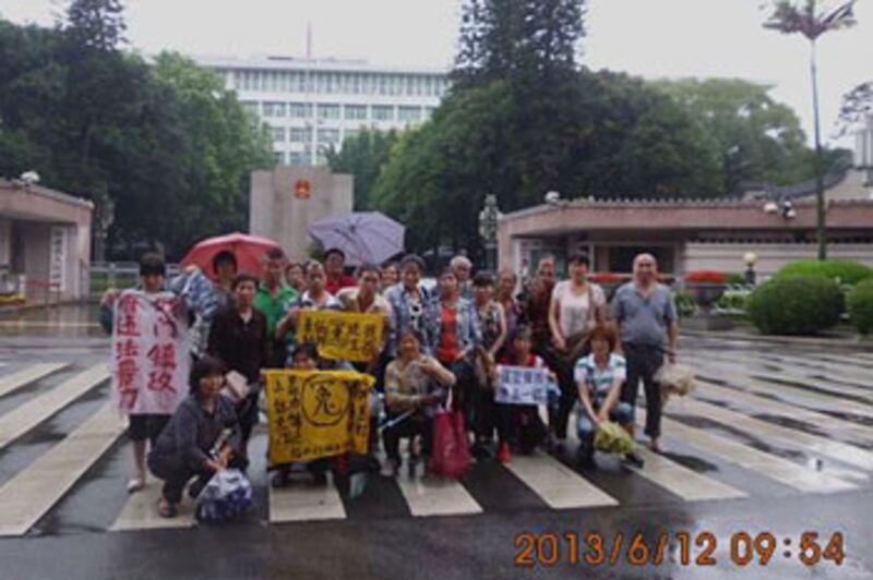 2013年6月12日，福建省五十多名老訪民，趁紀念愛國詩人屈原的端午節來臨，周三相約前往省政府為自己的冤情申訴，訪民們於省政府門口，手持狀紙、標語抗議。（相片來自六四天網） 