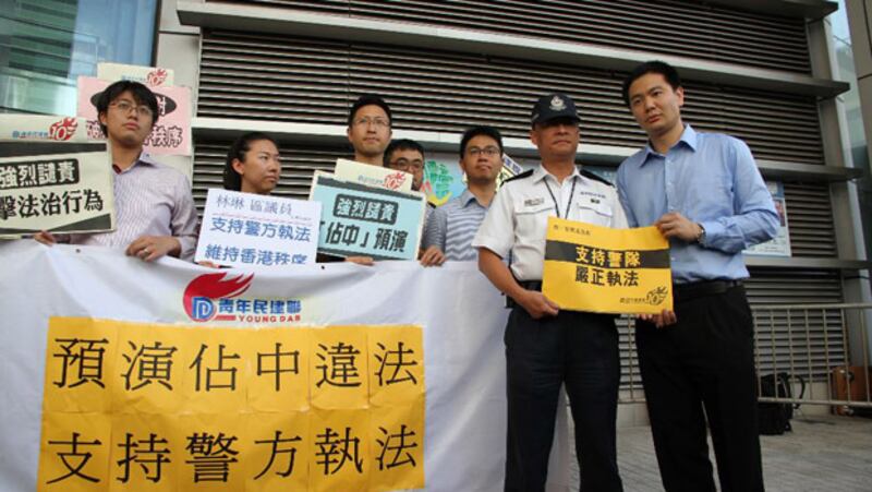 2014年7月4日，“青年民建聯成員”到警察總部外拉起橫額，支持警隊嚴正執法，並譴責學聯及市民日前留守中環遮打道。(粵語組林靜攝)