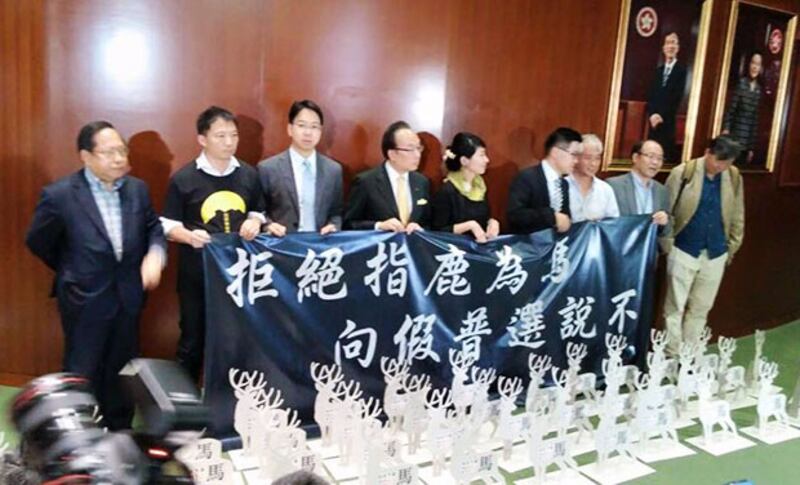 2015年5月28日，十多名泛民立法會議員於會議廳外，擺放鹿形的紙板圖，諷刺港府提出的政改方案“指鹿為馬”、“以假當真”欺騙市民。(民主黨提供)