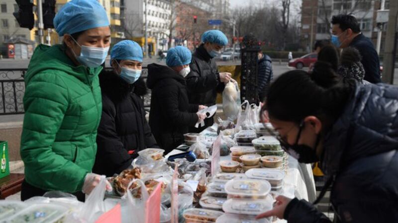 北京一家餐馆在餐厅外面贩售外带餐点,新冠肺炎疫情已对许多生意造成影响。(法新社)