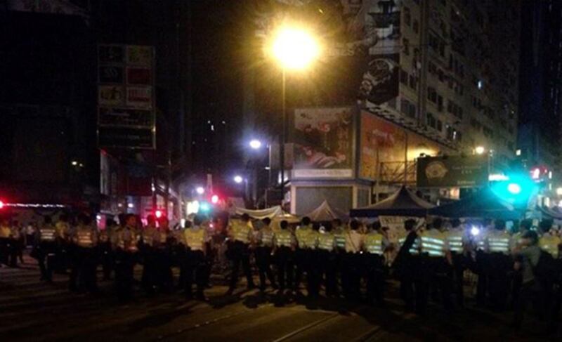 2014年10月14日，清晨五時，警員突然包圍銅鑼灣防線，拆走在佔領區內鐵馬。（學聯 facebook）