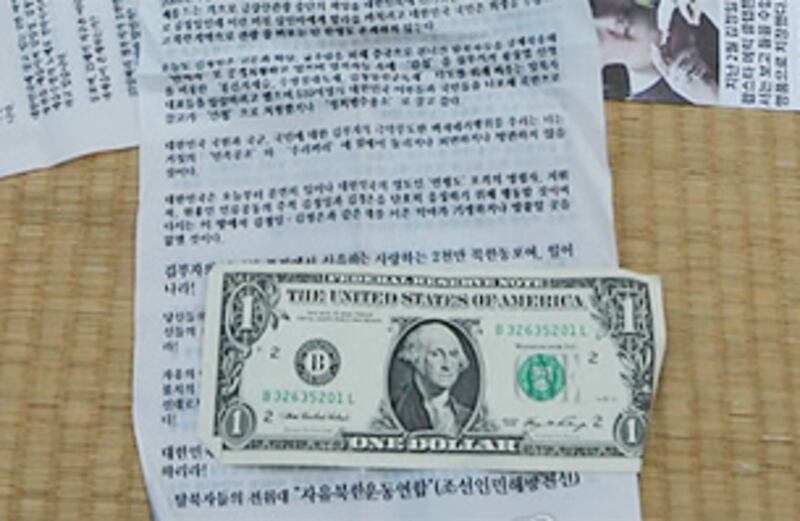 탈북자단체가 대북풍선에 넣은 전단지와 미화 1달러 지폐.