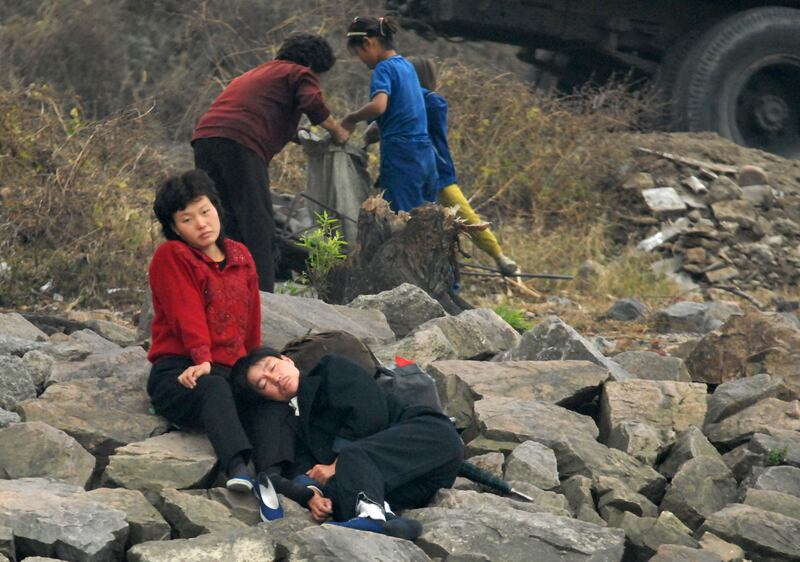 2006년 10월 15일, 북한 신의주에서 한 북한인 남녀가 압록강변에서 쉬고 있다.