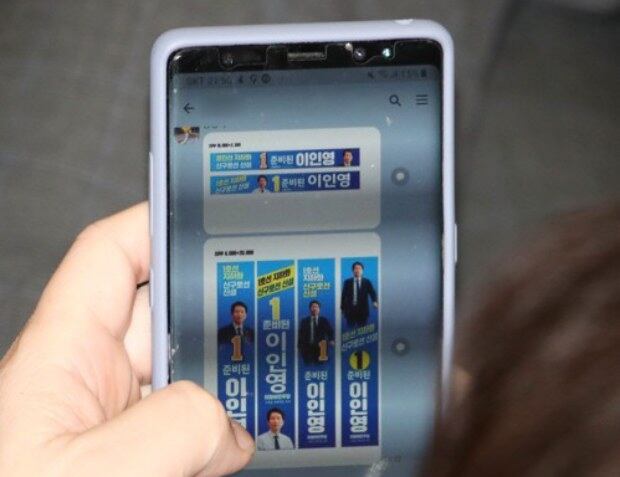 스마트폰으로 4.15총선 관련 홍보물을 살펴보는 모습.