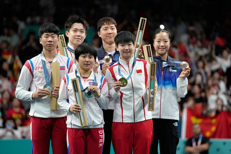 2024年7月30日,朝鲜、中国、韩国运动员在巴黎奥运发奖仪式上合影。(美联社)