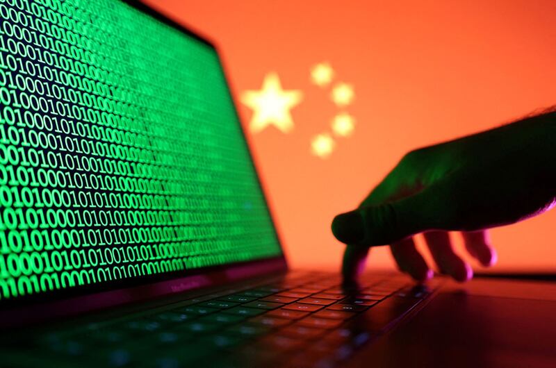 中国国旗旁边一台笔记本电脑上显示的二进制代码(路透社)