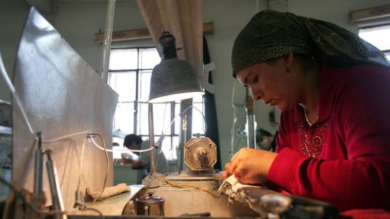 一名维吾尔族妇女在新疆一家工厂内清洗玉器(法新社)