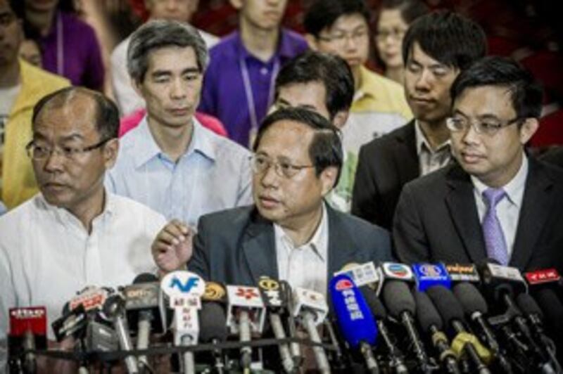 图片： 民主党成员召开记者会，何俊仁（中）宣布辞去主席职务。 （法新社图片）