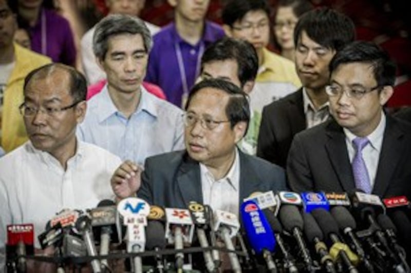 图片: 民主党成员召开记者会,何俊仁(中)宣布辞去主席职务。 (法新社图片)
