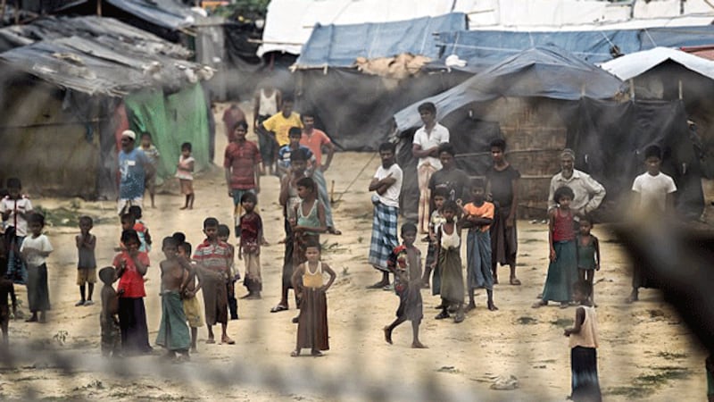Rohingya refugees gather near their shelters in the ‘no-man's land' behind a barbed-wire fence along the Myanmar-Bangladesh border in Maungdaw district, western Myanmar's Rakhine state, April 25, 2018. 