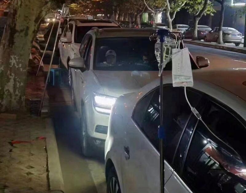武漢醫療系統受到衝擊,醫院人滿為患。病人只能在路邊車內吊鹽水。(網絡圖片/古亭提供)