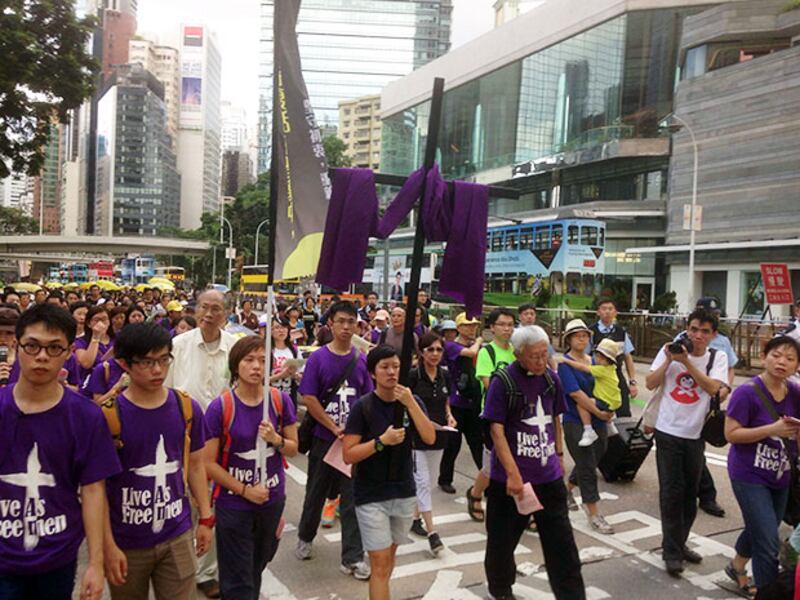 香港天主教正義和平委員會舉辦苦行反對政改方案,遊行人士手持十字架及大型橫額前往政府總部。 (公教報facebook圖片)