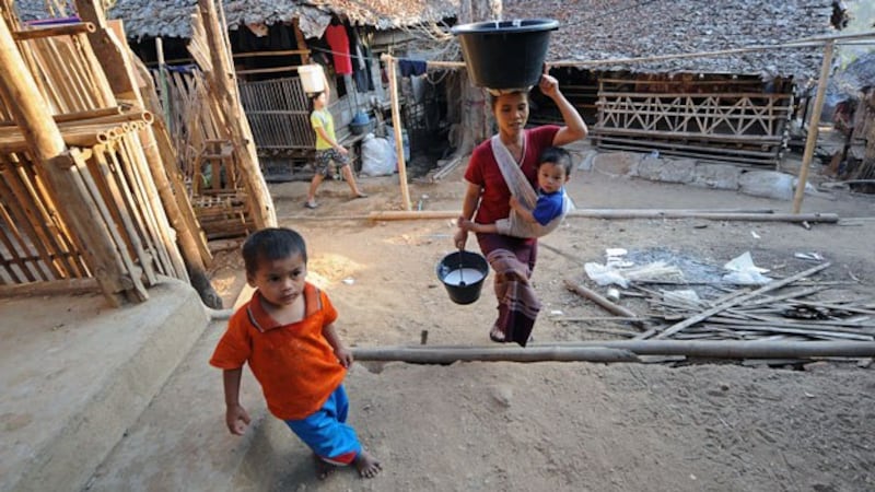Ethnic Karen refugees walk past shelters inside the Mae La refugee camp in Mae Sot near the Thai-Myanmar border in a file photo.