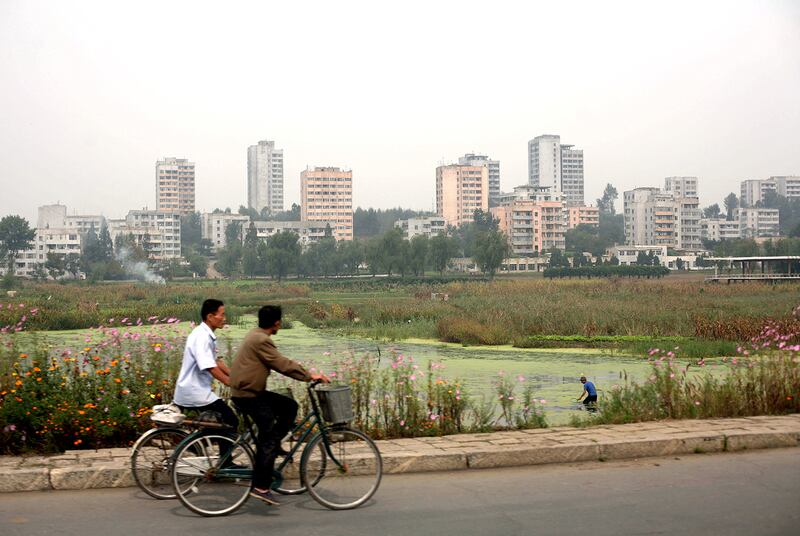 Men ride bicycles past the western coastal city of Nampo, North Korea, Sept. 19, 2008.