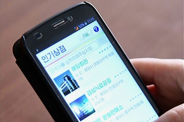 사진은 북한 주민이 휴대폰으로 쇼핑하는 모습.