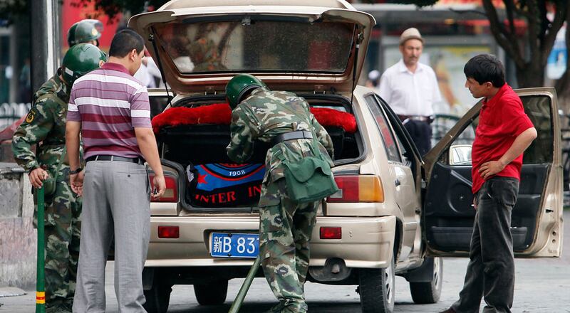 خىتاي قوراللىق ئەسكەرلىرىنىڭ بىر ئۇيغۇر ياشنىڭ ماشىنىسىنى ئاقتۇرۇۋاتقان كۆرۈنۈشى. 2009-يىلى 14-ئىيۇل، ئۈرۈمچى.