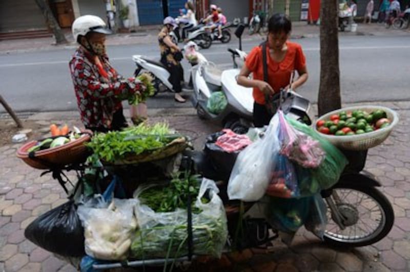 Một người bán rau dạo trên đường phố Hà Nội ngày 05 tháng 9 năm 2016. AFP photo