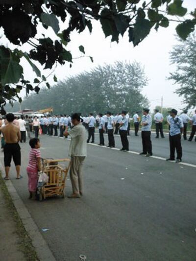 图片：三百警察出动封锁了公路，村民聚集围观，到底谁扰乱了交通？（目击者拍摄/记者丁小）