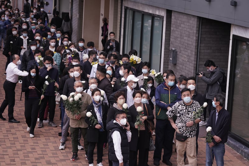 有不少市民手持鮮花到場悼念，但須提前預約及檢測陰性，及全程須戴N95或以上標準口罩。（石頭 攝）