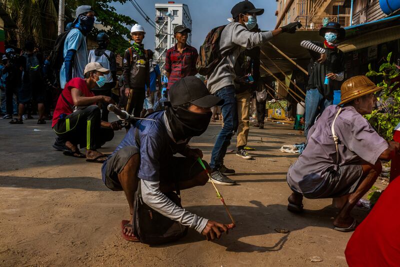 Anti-coup protesters prepare to use slingshots against security forces on March 28, 2021 in Yangon, Myanmar.