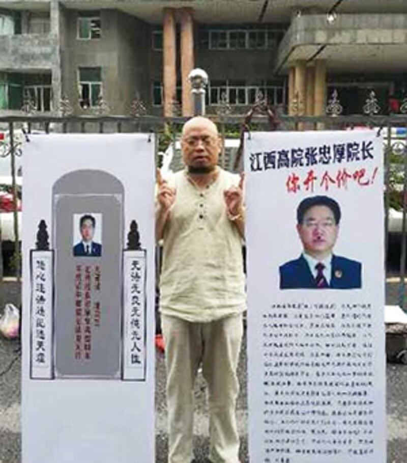 2015年5月19日,褔建維權人士屠夫,手持兩張貼上高院院長的紙牌,在法院外聲援律師。(照片來自維權人士)