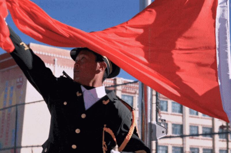 A Chinese military veteran posted as an “on-campus instructor” at a state-run middle school in Sernye District in Nagchu, Tibet Autonomous Region, leads a flag hoisting ceremony, March 18, 2025.