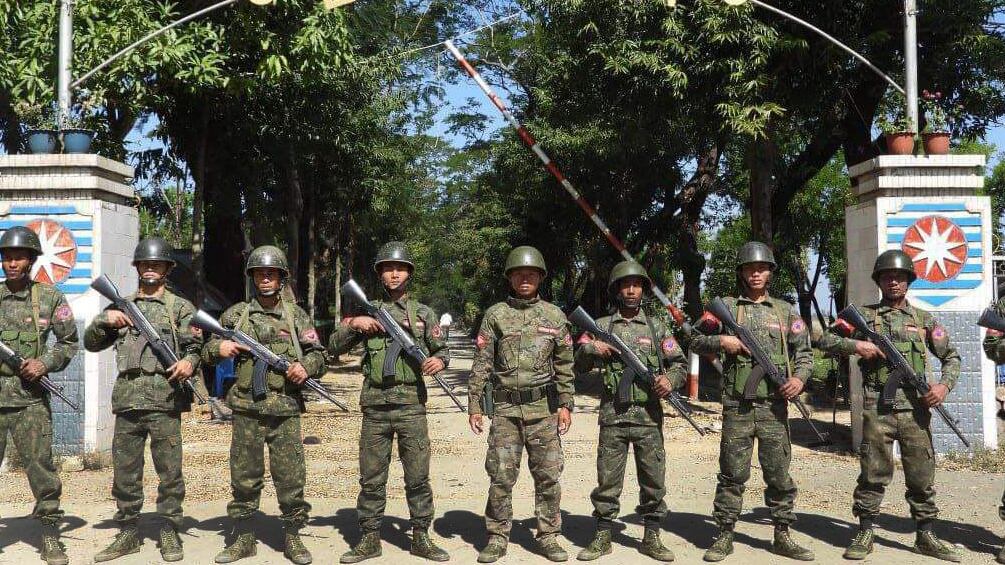Arakan Army soldiers pose in front of the Myanmar junta’s Western Regional headquarters in Kyauktaw after capturing it on Feb. 13, 2024.