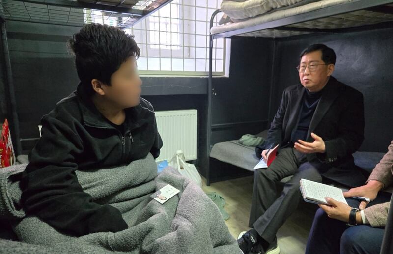 A North Korean soldier, left, identified as Baek, captured in Kursk and now at an unidentified detention center in Ukraine. Part of the image has been blurred by South Korean lawmaker Yu Yong-weon, right, who interviewed the soldier.