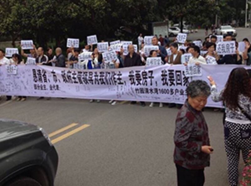 2015年5月26日,業主其後手持橫額,把市政府大樓外的車輛出入通道堵死。(業主攝)