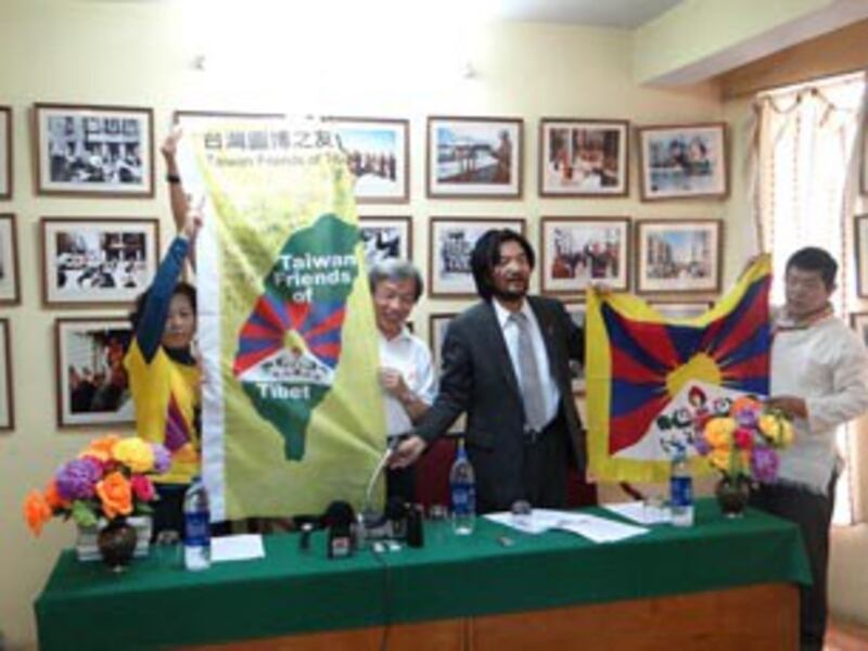 图片：台湾图博（西藏）之友会与对方交换旗帜。（丹珍摄）