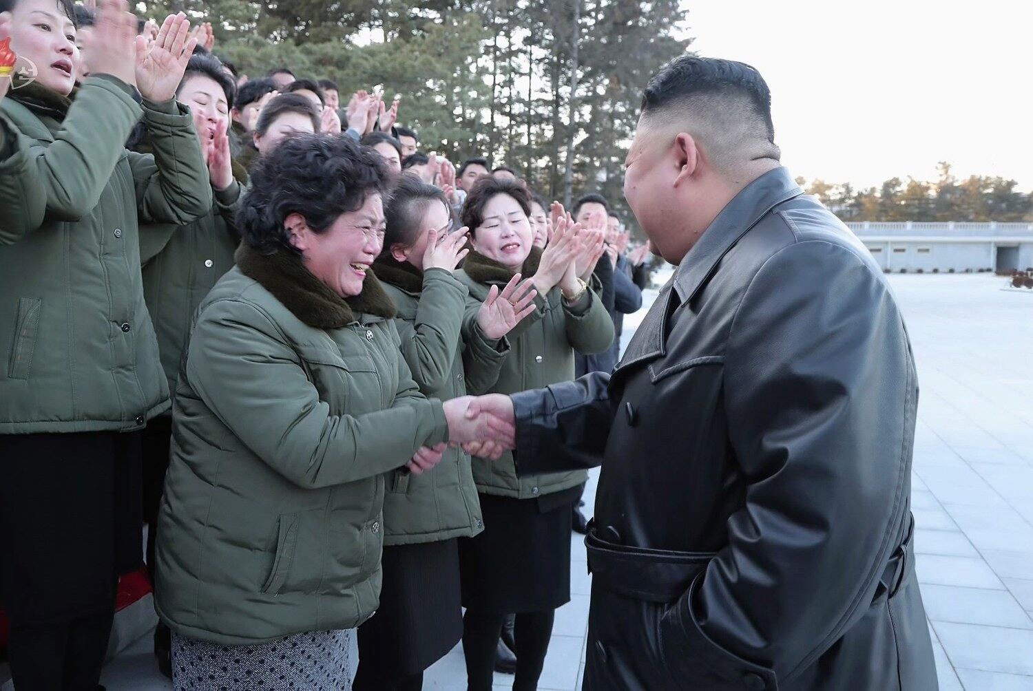 북한 김정은 국무위원장이 근로자들의 손을 잡으며 당대회 준비 노고를 격려하는 모습.