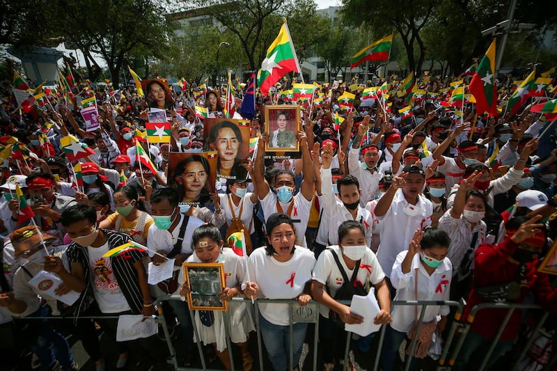 Myanmar nationals display pictures of deposed Myanmar leader Aung San Suu Kyi during a protest against the military coup in front of the United Nations building in Bangkok, Thailand, March 2021. Credit: Nava Sangthong/AP