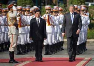 Tổng Thống Hoa Kỳ George W. Bush (phải) và Chủ Tịch Nước Việt Nam Nguyễn Minh Triết duyệt hàng quân danh dự tại Dinh Chủ Tịch hôm 17-11-2006. AFP PHOTO