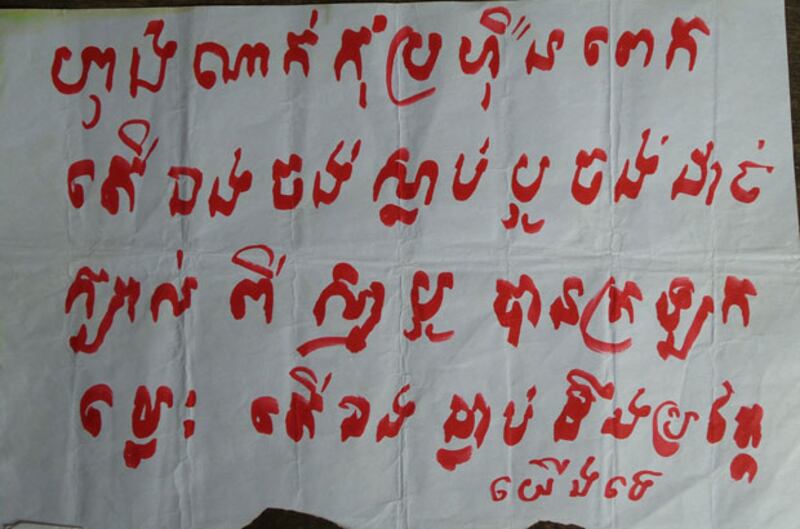 ខិត្តប័ណ្ណដែលជនមិនស្គាល់មុខសរសេរដោយដៃគំរាមសម្លាប់និងកាត់ក្បាលសកម្មជនគណបក្សសង្គ្រោះជាតិ នៅឃុំកំពង់ភ្លុក ស្រុកប្រាសាទបាគង ខេត្តសៀមរាប។ រូបថតថ្ងៃទី២៩ វិច្ឆិកា ឆ្នាំ២០១៤